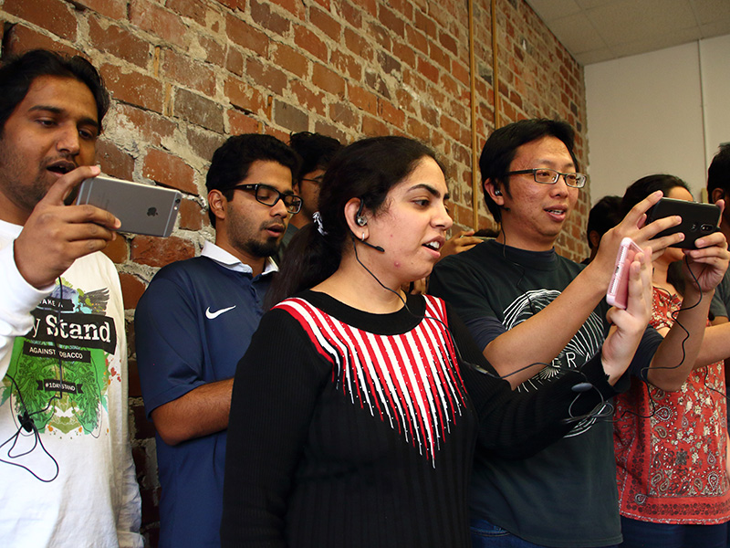 An ensemble of singers with smartphones performs.
