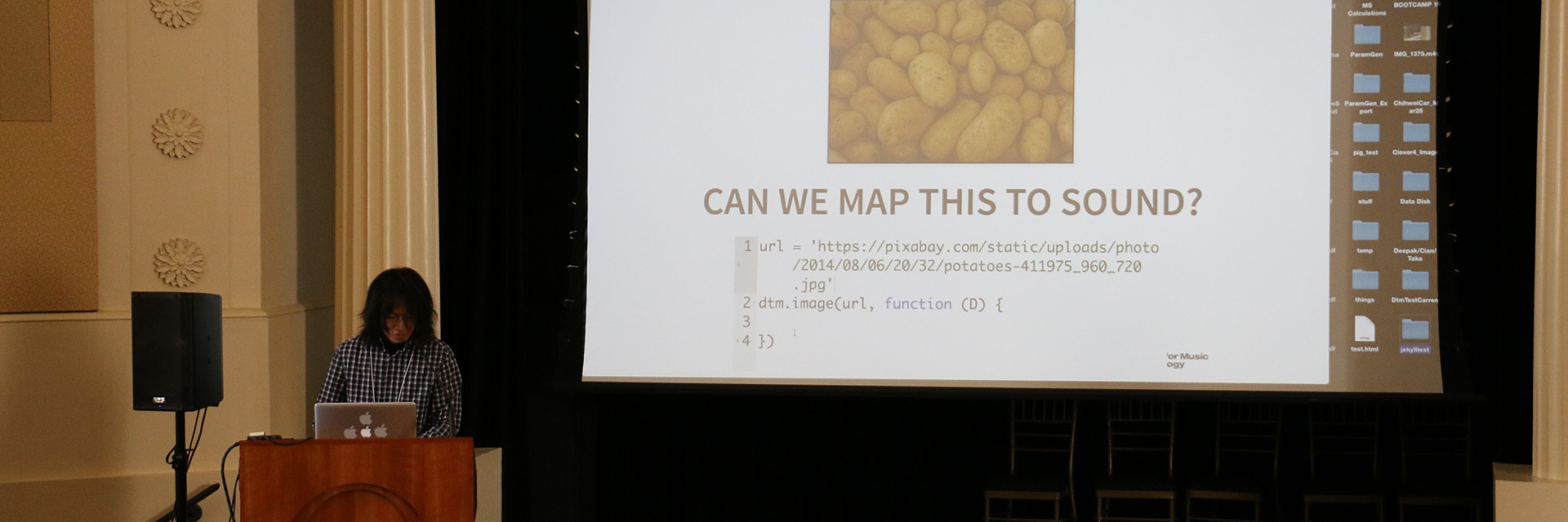 A woman makes a presentation in front of a projected image.